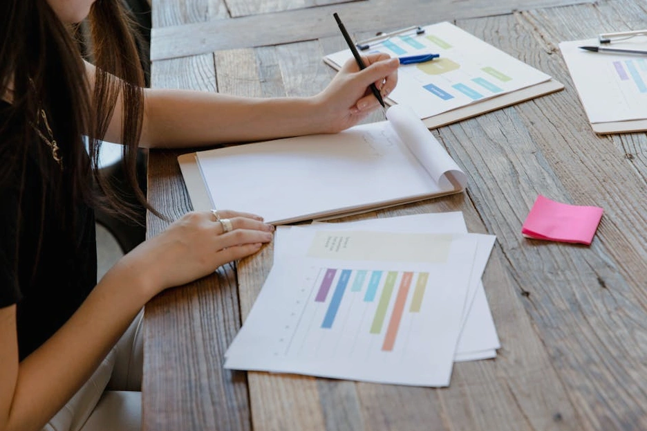 Osoba skupiona na planowaniu strategii biznesowej przy biurku.